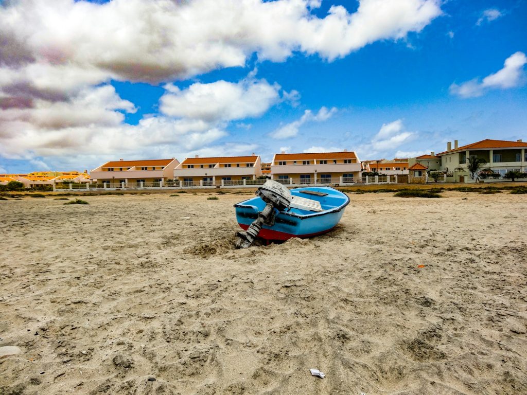 Vila costeira com barco na areia